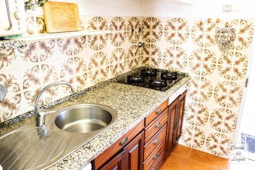 a kitchen with a sink and a stove at Encanto da Praia in Santo André