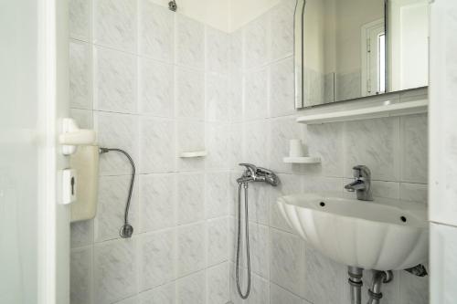 a white bathroom with a sink and a mirror at Angela partial sea view 9 in Kefallonia