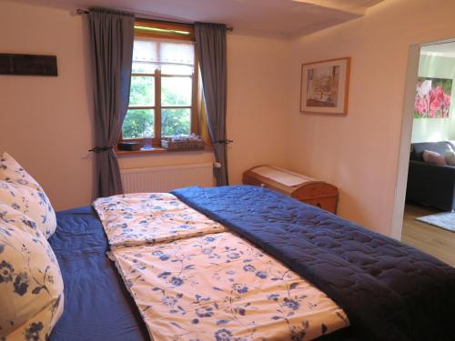 a bedroom with a bed with a blue comforter and a window at Fachwerktraum im Hof in Alheim
