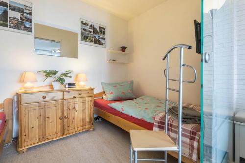 a small bedroom with a bunk bed and a chair at Ferienwohnung Harzblick in Altenau