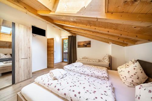 due letti in una stanza con soffitto in legno di Eggerhof Suite a Verano