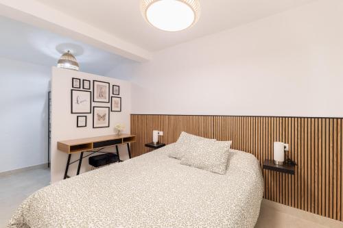 a bedroom with a bed and a wooden wall at El Castañar de Ceubia in Arenas de San Pedro