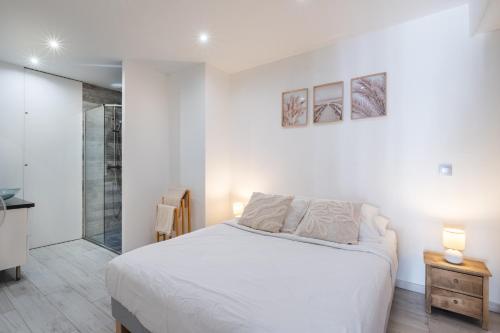 a white bedroom with a bed and a glass shower at T2 Cyril Besset in Cagnes-sur-Mer