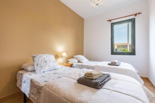 two beds in a room with a window at Villa Orquidea in Tamaragua