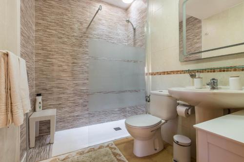 a bathroom with a toilet and a sink and a shower at Villa Orquidea in Tamaragua