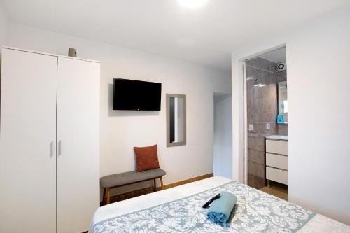 a bedroom with a bed and a chair and a television at Apartamento La Morena 3a in El Pris