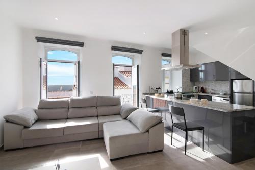 a living room with a couch and a kitchen at Traditional 3 bedroom apartment in Alte