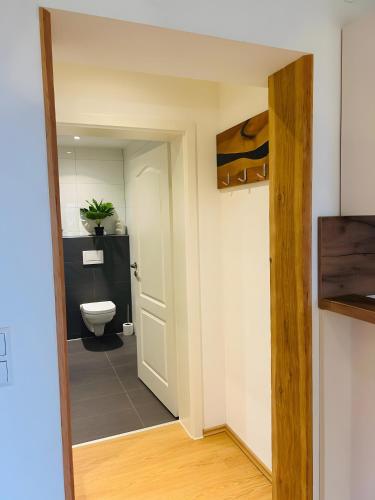 a bathroom with a toilet and a white door at Ferienwohnung Bauernpfad in Kressbronn am Bodensee