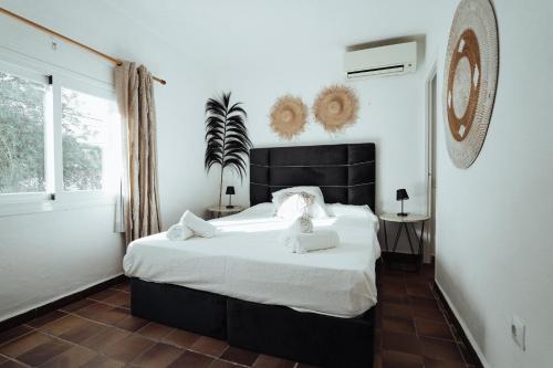 a bedroom with a large bed with white sheets at Villa Carol in Illes Balears