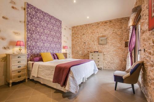 a bedroom with a bed and a chair in a room at Casa Rural La Morisca in Tuineje