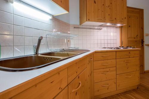 a kitchen with a sink and wooden cabinets at Lindenhof Apt 4 in Vandoies