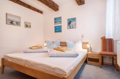a bedroom with two beds and a chair at Ferienwohnung Nr 3 in Deggenhausertal