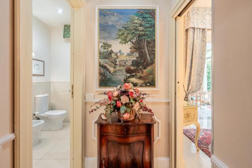a bathroom with a vase of flowers on a table at Villa Manuela Flat in Chiesina Uzzanese