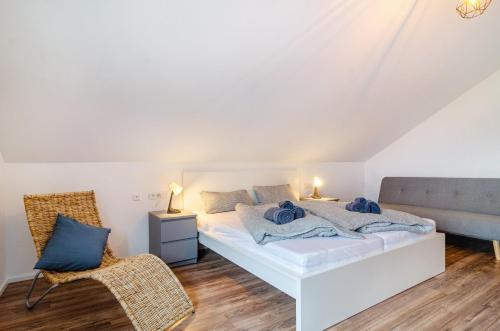 a bedroom with a white bed and a chair at Sonne und Mehr in Stockach