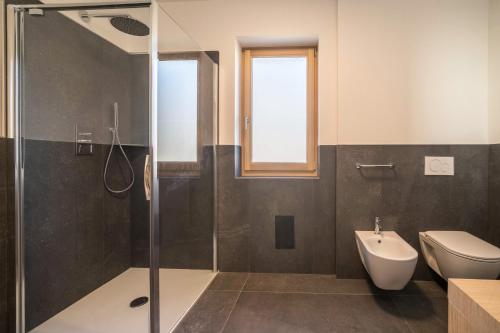 a bathroom with a shower and a toilet and a sink at Apt Lärche - Nockerhof in Andrian