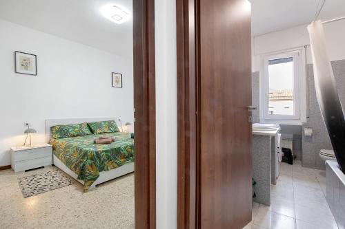 a bedroom with a bed and a bathroom with a window at A due passi dalle terme e dal lago in Trescore Balneario
