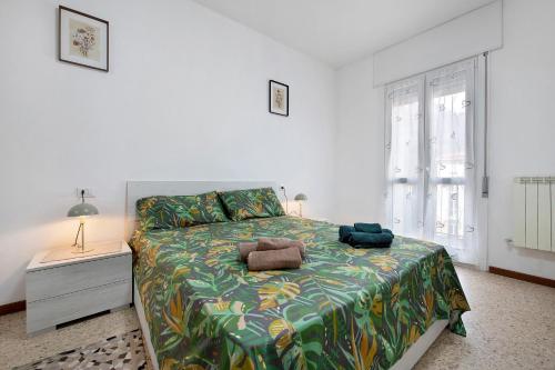 a bedroom with a bed with a green and yellow blanket at A due passi dalle terme e dal lago in Trescore Balneario
