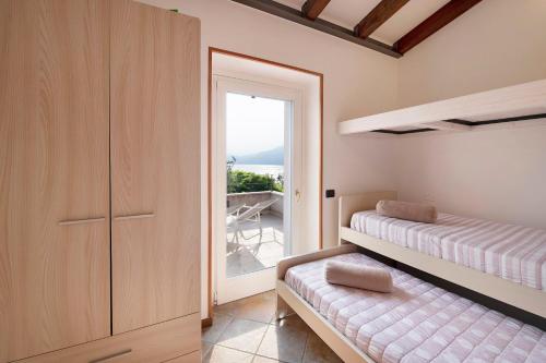a bedroom with a bed and a door to a balcony at Rustico alle Fornare in Torri del Benaco