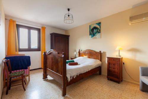 una camera da letto con un letto, un comò e una sedia di La Clavelle a Sanary-sur-Mer