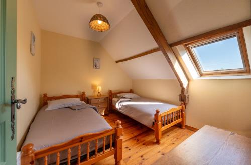 two twin beds in a room with a window at Domaine de Lestroué - Belle-île in La Vraie-Croix