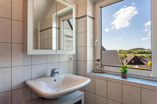 a bathroom with a sink and a window at Ferienhaus Am Brande in Schmallenberg