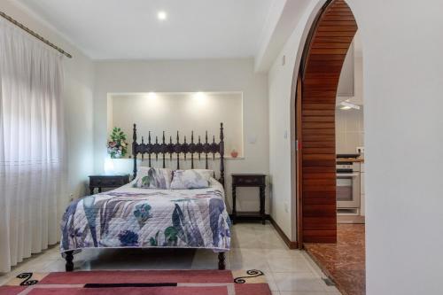 a bedroom with a bed and two tables and a hallway at Estúdio entre Porto e Aveiro in Carregosa