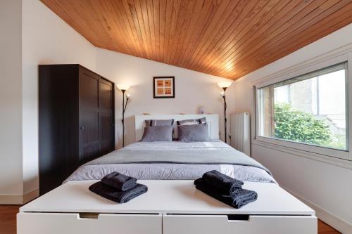 a bedroom with a large bed and a window at A Bordeaux, Climatisée avec billard in Le Bouscat