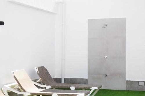 a room with two chairs and a green rug at Alce piscina climatizada in Chiclana de la Frontera