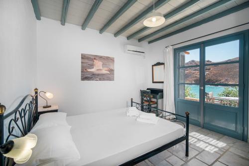 a bedroom with a bed and a large window at Ammos 1 in Serifos Chora