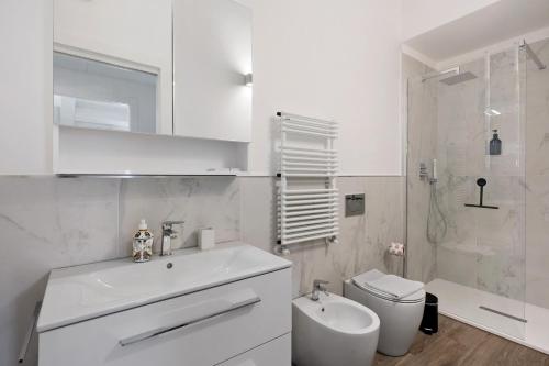 a white bathroom with a sink and a toilet at Cinema Boutique Apartment Sestri in Sestri Levante