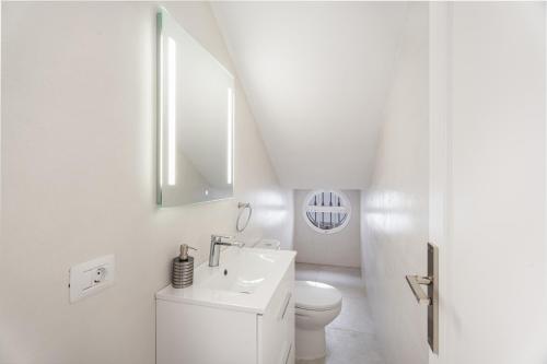 a white bathroom with a sink and a toilet at Villa en Las Caletillas in Punta Larga