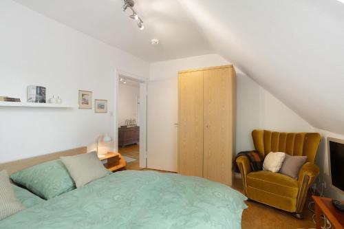 a bedroom with a bed and a chair at Schöne Dachgeschoss Wohnung in Warstein