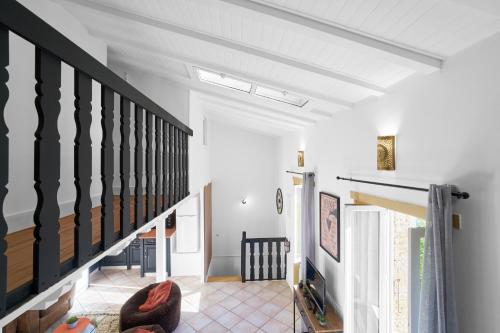 a living room with a staircase and white walls at Maison Séjour Capraisien in Saint-Capraise-de-Lalinde