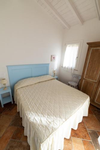 a bedroom with a large bed with a blue headboard at L' Elicriso in Marciana