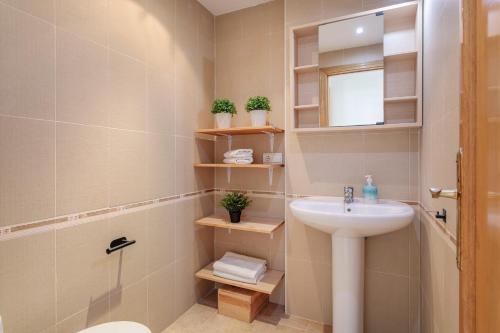 a bathroom with a sink and a toilet and a mirror at El Mirador in Mutxamel