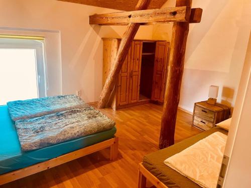 a bedroom with a bed and a wooden floor at Alter Stall in Melzow