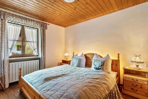 a bedroom with a bed with a wooden ceiling at Ferienwohnung an den Bergen in Unterwössen