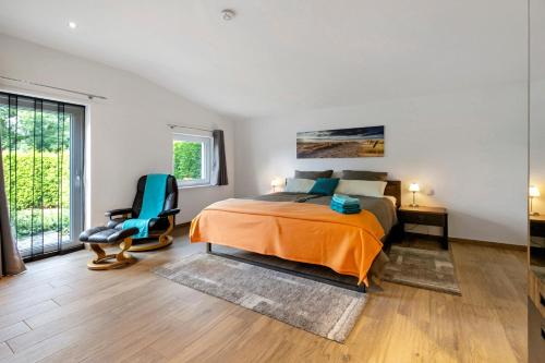 a bedroom with a bed and a chair in it at Ferienwohnung Offenbütteler Moor in Osterrade