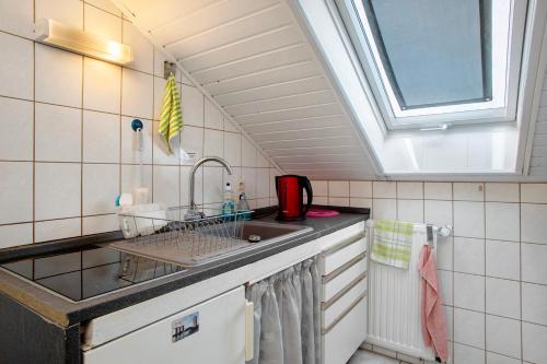 a small kitchen with a sink and a window at Apfelstübchen in Friedrichshafen