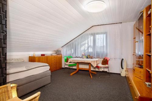a bedroom with a bed and a table in a room at Apfelstübchen in Friedrichshafen