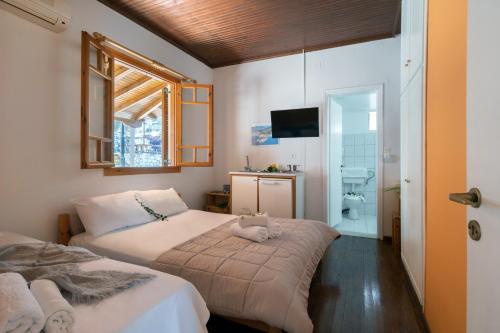 a bedroom with two beds and a bathroom with a tv at Krinos apartment 1 in Kharadhiátika