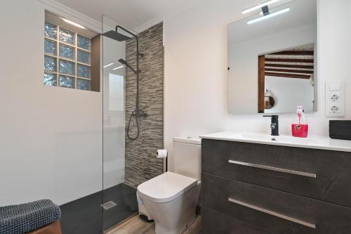 a bathroom with a toilet and a sink and a shower at Dulce in Benissa