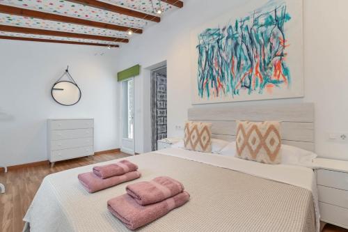 a bedroom with a large bed with two pink towels at Dulce in Benissa