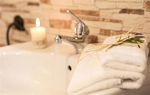 a white towel on a sink with a candle at Pinnetta Sarda in Codrongianos