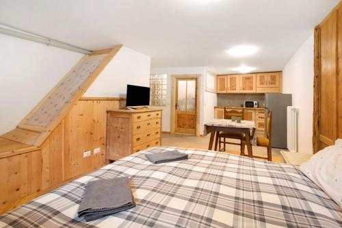 a bedroom with a bed and a kitchen at Premesan 4 in Bormio