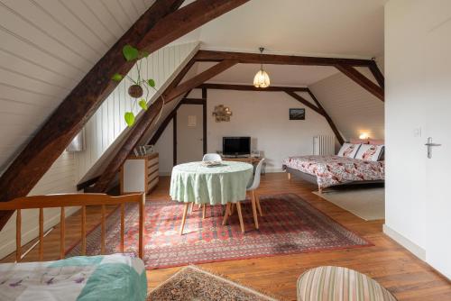 a living room with a table in a attic at Chambres D'hôtes Maison Galouÿe in Montgaillard