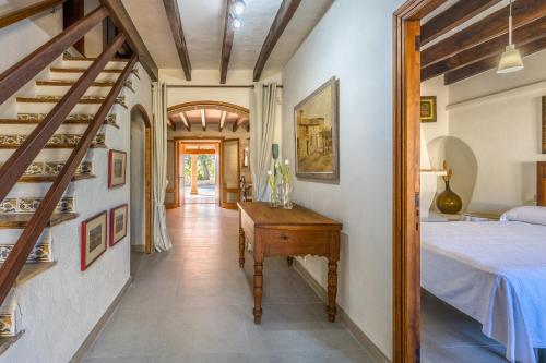 a hallway with a bed and a desk in a room at Can Pou Petit in Pollença