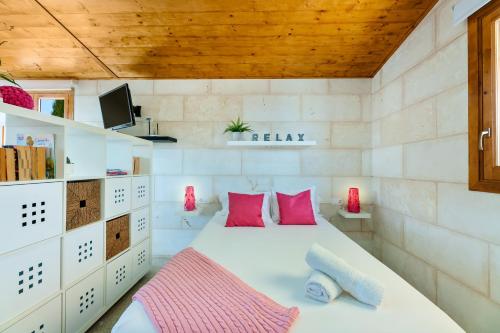 a bedroom with a bed with pink pillows at Biniaco in Muro