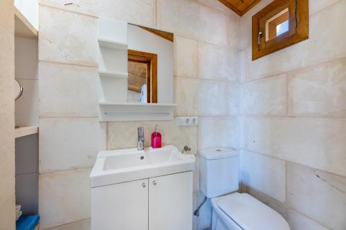 a bathroom with a white sink and a toilet at Biniaco in Muro