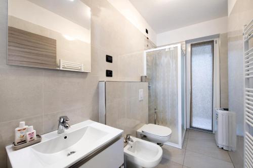 a white bathroom with a sink and a toilet at Appartamento 3 Il Tornante in Nesso